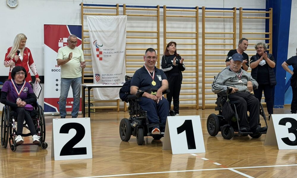 Fotografija prikazuje troje ljudi u invalidskim kolicima koji imaju medalje oko vrata, a ispred njih je broj mjesta kojeg su osvojili.