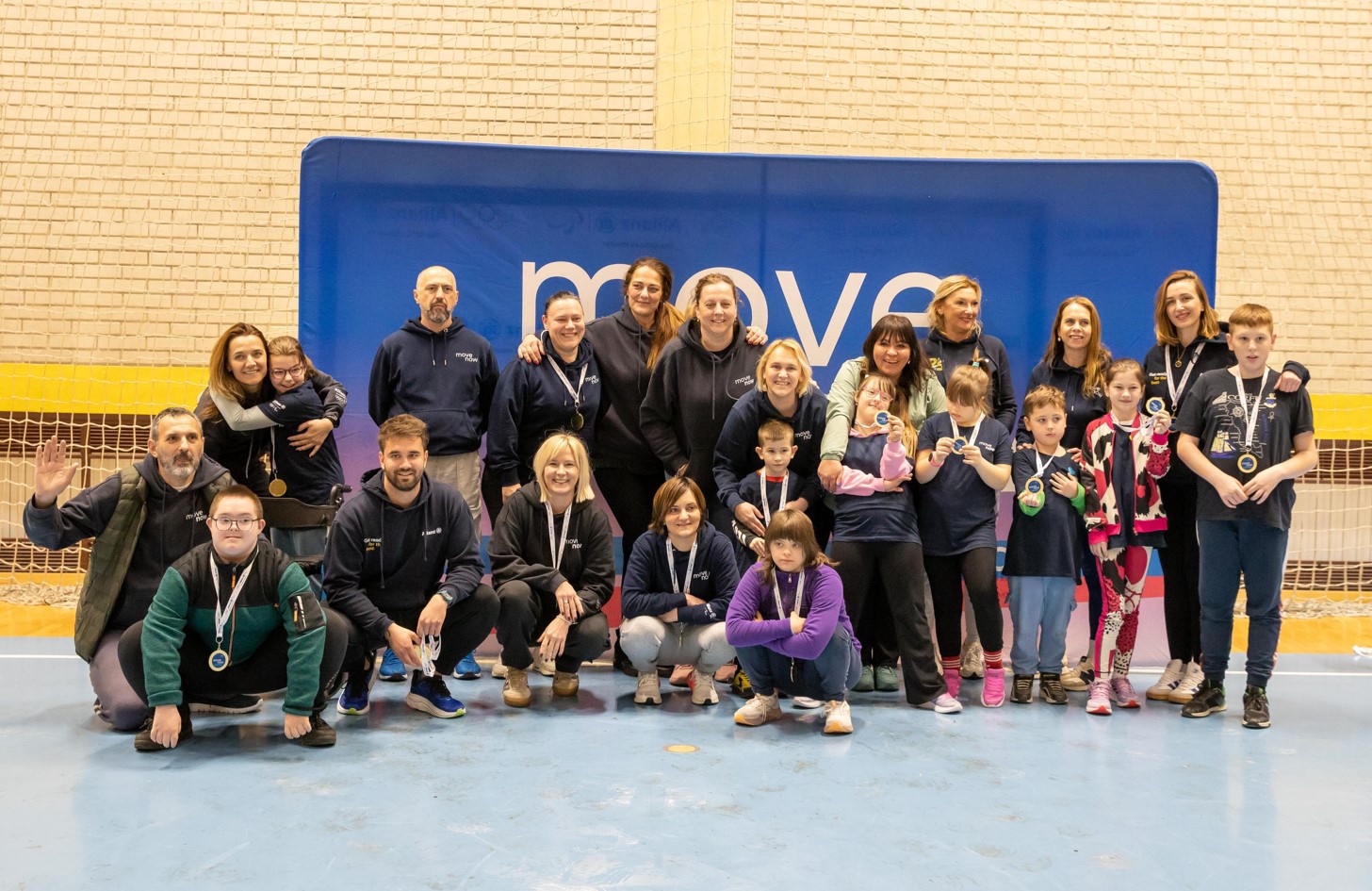 Sudionici i treneri poziraju s medaljama nakon sportskog programa.