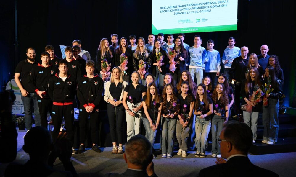 Fotografija prikazuje više osoba koje stoje na pozornici.