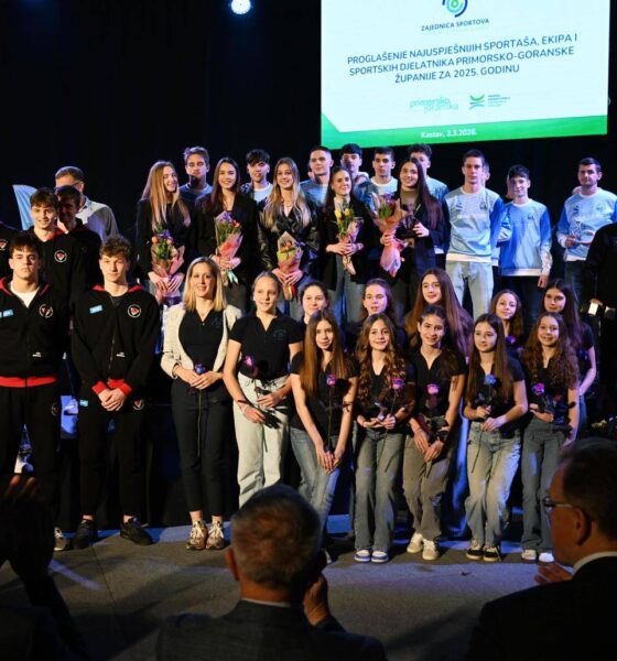 Fotografija prikazuje više osoba koje stoje na pozornici.