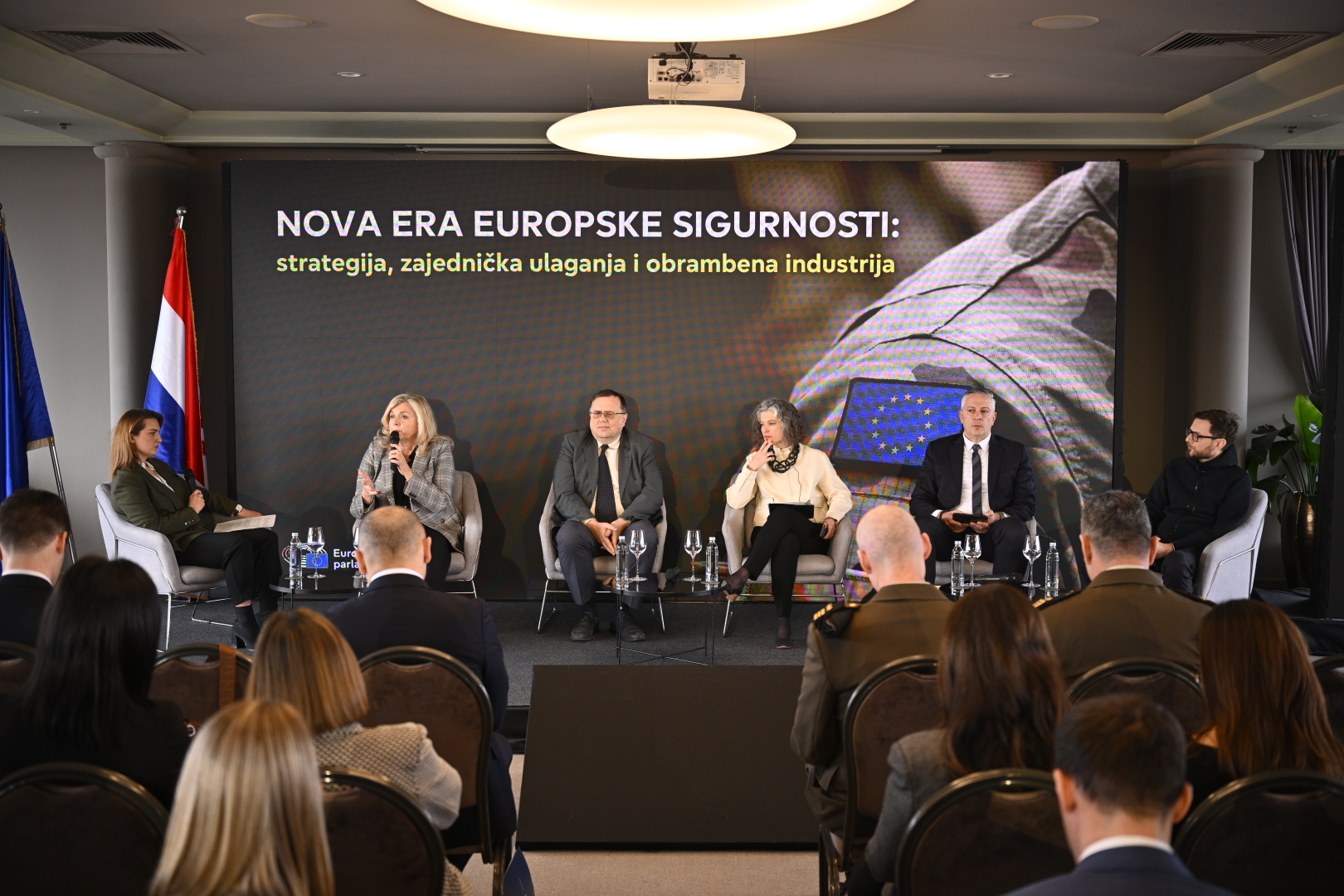 Panel rasprava o europskoj sigurnosti pred publikom i državnim zastavama.