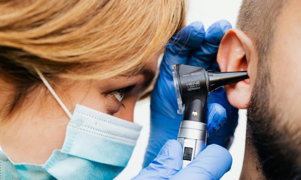 Na fotografiji se nalazi starija žena s kratkom sijedom kosom, koja sjedi na klupi u parku. Odjevena je u tamnoplavi kaput i crne hlače, a na nogama ima crne cipele. U rukama drži štap, a pored nje na klupi nalazi se torba. Pozadina prikazuje drveće bez lišća, što sugerira da je snimka nastala u jesen ili rano proljeće. Atmosfera fotografije djeluje mirno i pomalo melankolično.