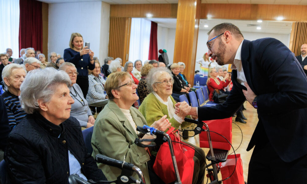 Muškarac se rukuje sa starijim ženama u domu za umirovljenike.