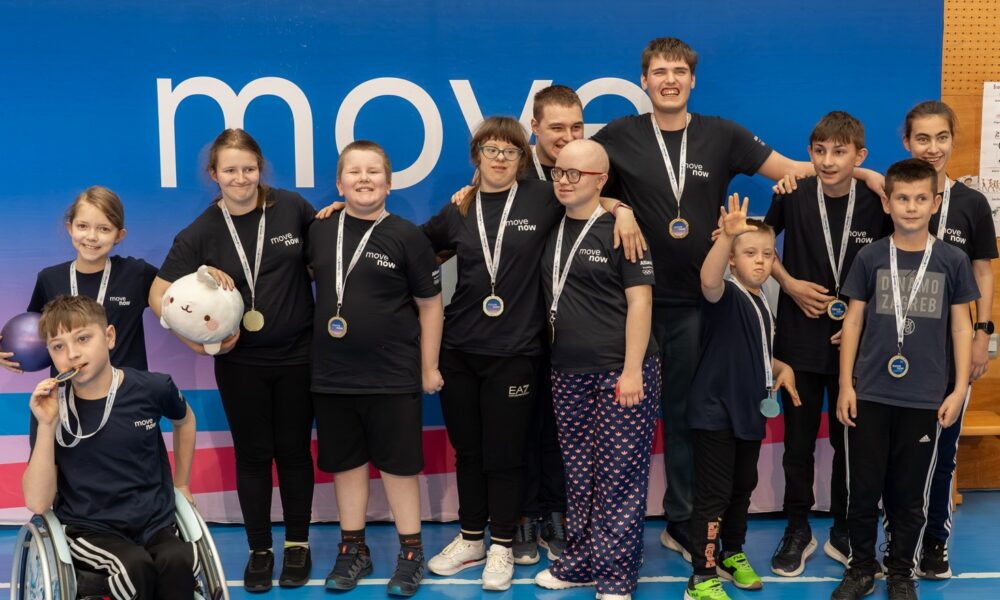 Fotografija prikazuje nekoliko djece s teškoćama u razvoju koji oko vrata imaju medalje. Jedan je dječak u kolicima, a jedna cura drži plišanu igračku.