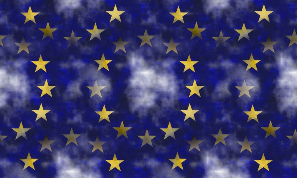 Stilizirana pozadina s motivom zastave Europske unije – zlatne zvjezdice na plavoj podlozi uz oblačne teksture.
