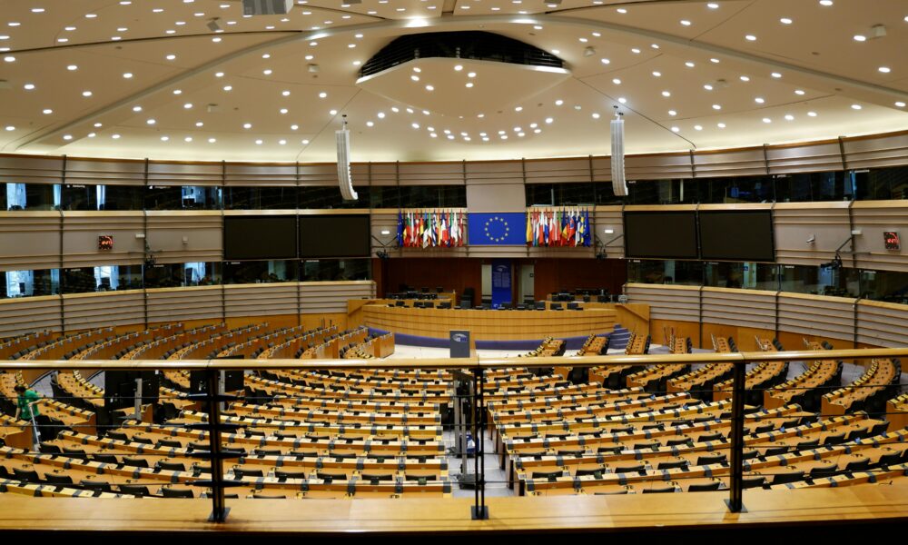 Fotografije prikazuje veliku dvoranu s puno mjesta, dok se u daljini vidi slika zastave Europske unije.