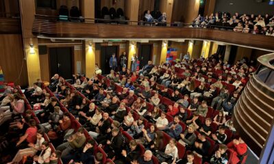Fotografija prikazuje ljude kako sjede u kazalištu.