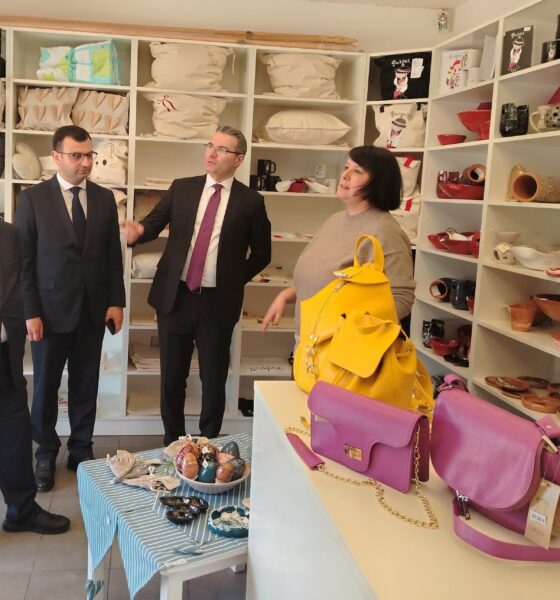 Fotografija prikazuje nekoliko ljudi u dućanu s raznim stvarima, a u prvom planu su torbe.