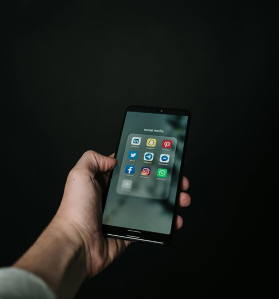 Fotografija prikazuje ruku koja drži mobitel na kojem se vide aplikacije