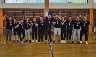 Fotografija prikazuje više ljudi, a ispred njih pehar.