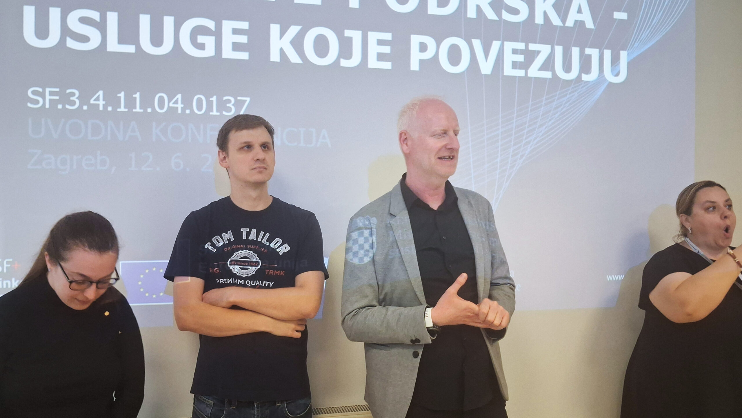 Govornici i prevoditeljica na znakovni jezik sudjeluju na konferenciji o uslugama podrške.