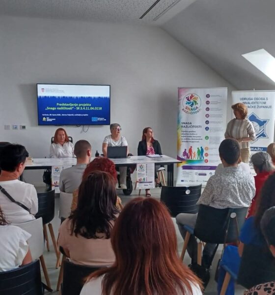 Na fotografiji je prikazan trenutak s početne konferencije projekta „Snaga različitosti“, održane u Multimedijskoj dvorani Kina Edison u Karlovcu. U prvom planu vidi se publika okupljena u dvorani, dok se u pozadini nalaze sudionice panela koje predstavljaju projekt i njegove aktivnosti. Jedna od govornica obraća se prisutnima, a iza nje su postavljeni promotivni roll-up plakati i ekran s nazivom projekta. Atmosfera djeluje radno i svečano, uz velik interes sudionika za teme socijalne uključenosti, podrške osobama s invaliditetom i razvoja socijalnih usluga u zajednici.