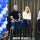 Panel-rasprava s troje sudionika ispred mikrofona i plavo-bijele dekoracije od balona.
