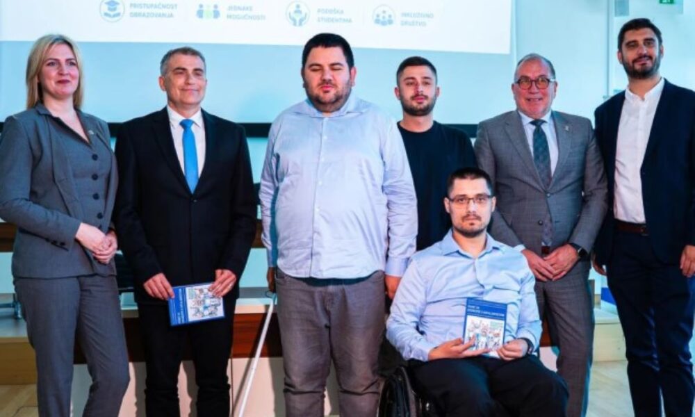 Na fotografiji se nalazi skupina ljudi okupljena na predstavljanju vodiča za studente s invaliditetom. U prvom planu pozira šest osoba, među kojima je jedan muškarac u invalidskim kolicima koji drži primjerak vodiča. Ostali sudionici stoje uz njega, odjeveni uglavnom u poslovnu i svečanu odjeću. U pozadini je projekcija s natpisom o studentima s invaliditetom te ilustracijama koje prikazuju jednakost i pravednost (“Equality” i “Equity”). Na ekranu se također vide pojmovi poput pristupačnosti obrazovanja, jednakih mogućnosti, podrške studentima i inkluzivnog društva. Atmosfera djeluje službeno i edukativno, kao dio konferencije ili javnog predstavljanja projekta vezanog uz inkluzivno obrazovanje.
