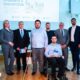 Na fotografiji se nalazi skupina ljudi okupljena na predstavljanju vodiča za studente s invaliditetom. U prvom planu pozira šest osoba, među kojima je jedan muškarac u invalidskim kolicima koji drži primjerak vodiča. Ostali sudionici stoje uz njega, odjeveni uglavnom u poslovnu i svečanu odjeću. U pozadini je projekcija s natpisom o studentima s invaliditetom te ilustracijama koje prikazuju jednakost i pravednost (“Equality” i “Equity”). Na ekranu se također vide pojmovi poput pristupačnosti obrazovanja, jednakih mogućnosti, podrške studentima i inkluzivnog društva. Atmosfera djeluje službeno i edukativno, kao dio konferencije ili javnog predstavljanja projekta vezanog uz inkluzivno obrazovanje.