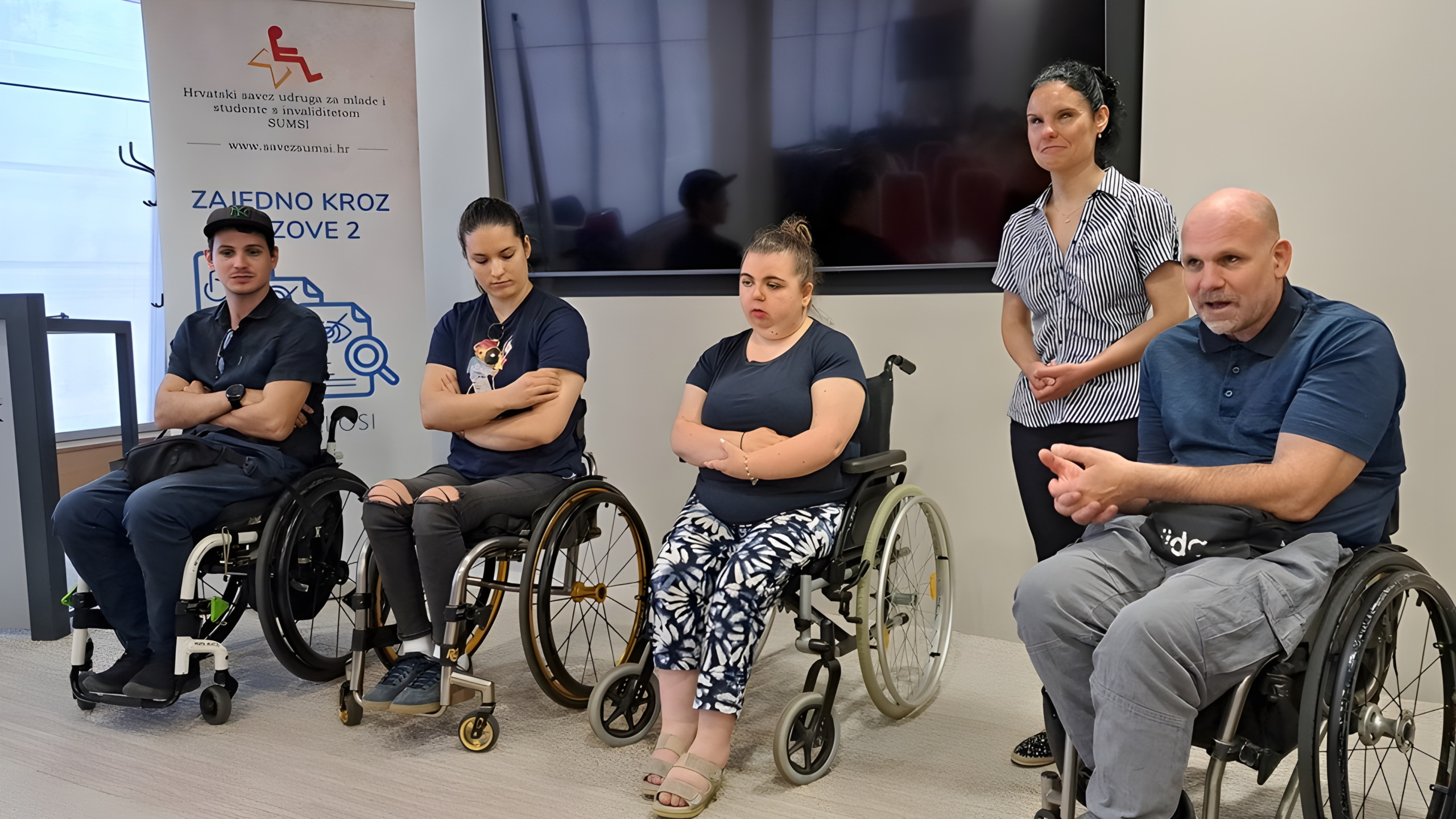 Sudionici, među kojima su osobe koje koriste invalidska kolica, sudjeluju u panel-raspravi o izazovima i pravima mladih osoba s invaliditetom.