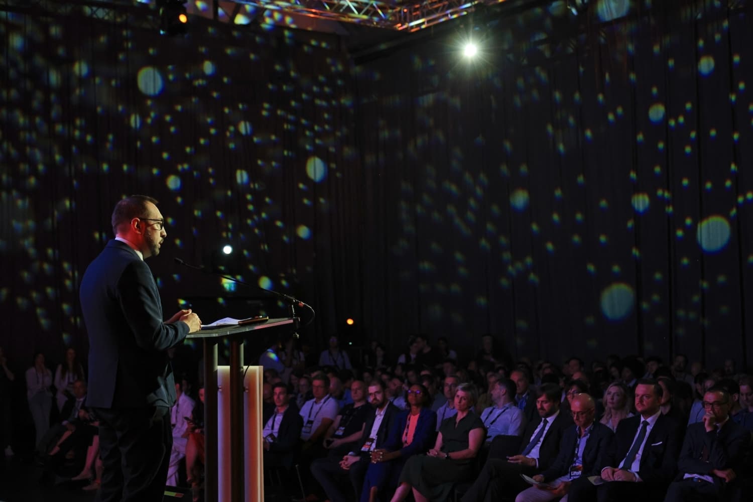Govornik na pozornici obraća se publici na konferenciji.