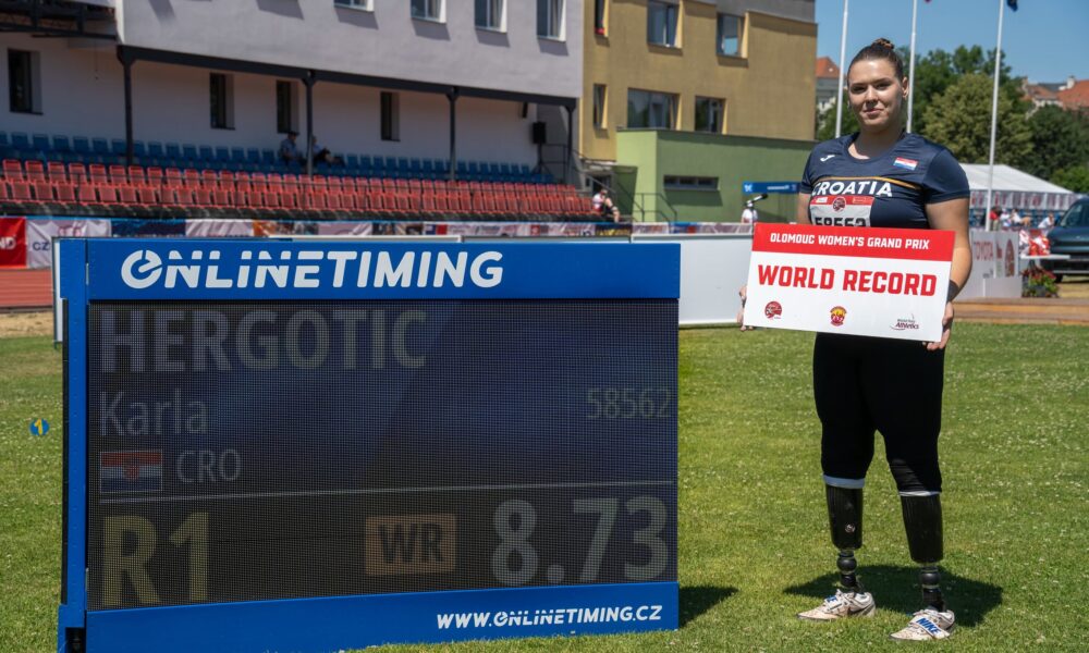 Hrvatska paraatletičarka drži ploču s natpisom "World Record" na atletskom stadionu.