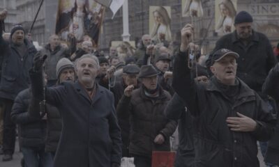 Skupina vjernika moli s krunicama na javnom okupljanju.