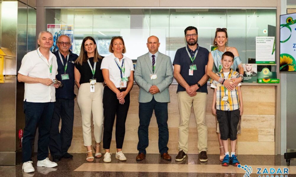 Na fotografiji se nalazi osam osoba koje poziraju u prostoru Zračne luke Zadar, ispred staklenog zida i informacijskog pulta. Skupinu čine zaposlenici zračne luke, predstavnici uključeni u projekt te žena s dječakom, koji stoje na desnoj strani fotografije. Većina prisutnih nosi akreditacije oko vrata, što upućuje na službeni događaj ili predstavljanje nove inicijative. U pozadini su vidljivi promotivni plakati programa Hidden Disabilities Sunflower sa simbolom suncokreta, uključujući poruku na engleskom jeziku: "Not every disability is visible – some are hidden" ("Nije svaki invaliditet vidljiv – neki su nevidljivi"). Na desnoj strani nalazi se i zaslon s logotipom Zračne luke Zadar i motivom suncokreta. Svi sudionici gledaju prema kameri i nasmiješeni su, ostavljajući dojam svečanog obilježavanja pristupanja Zračne luke Zadar programu Hidden Disabilities Sunflower. U donjem desnom kutu fotografije nalazi se logotip Zadar Airporta.