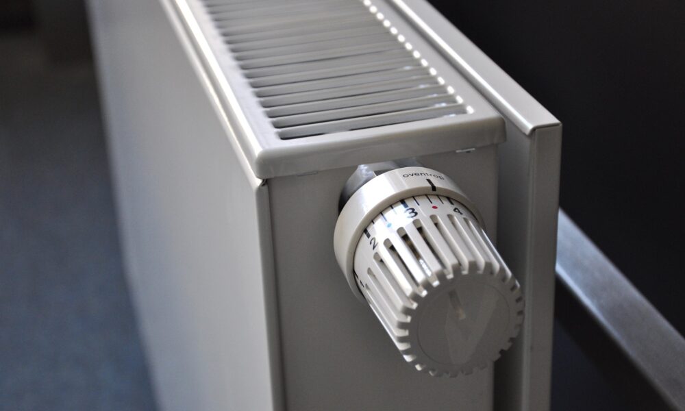 Bijeli radijator s termostatskim ventilom postavljenim na srednju temperaturu.