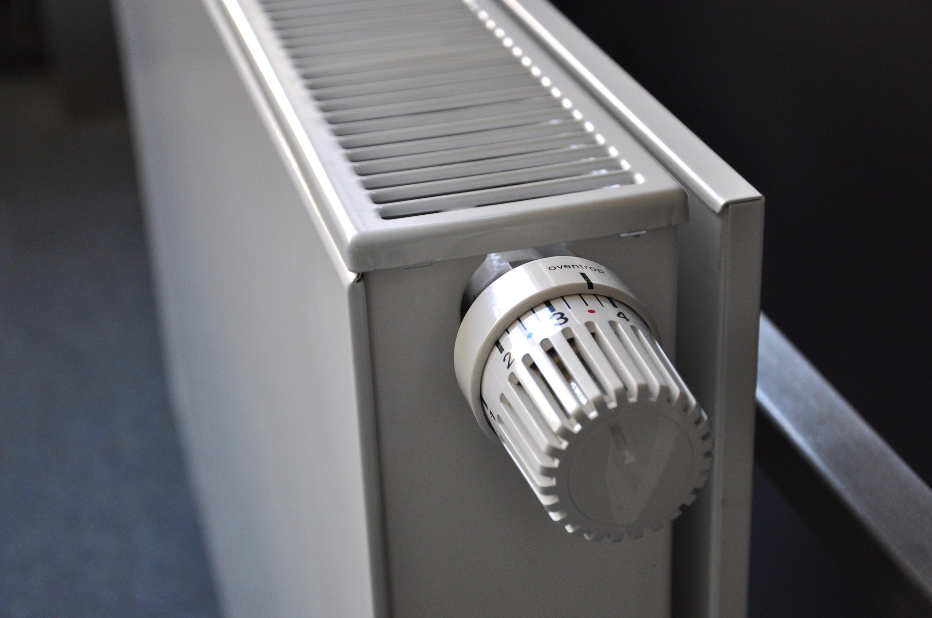 Bijeli radijator s termostatskim ventilom postavljenim na srednju temperaturu.