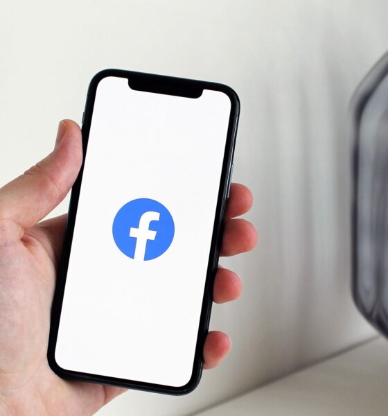 Ruka drži pametni telefon na čijem je zaslonu prikazan logotip Facebooka.