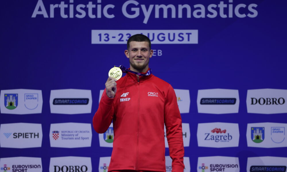 Gimnastičar u hrvatskoj sportskoj opremi pokazuje osvojenu zlatnu medalju.