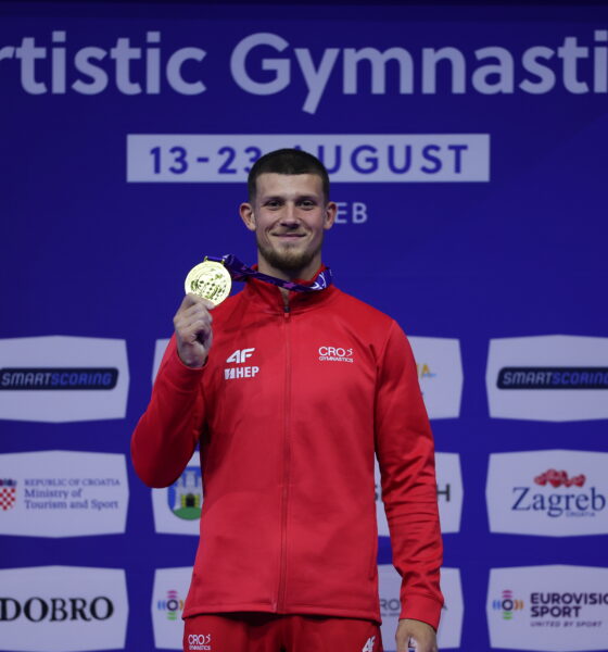 Gimnastičar u hrvatskoj sportskoj opremi pokazuje osvojenu zlatnu medalju.
