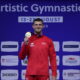 Gimnastičar u hrvatskoj sportskoj opremi pokazuje osvojenu zlatnu medalju.