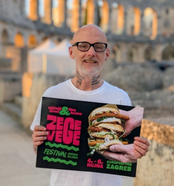 Muškarac drži plakat festivala ZeGeVege, a u pozadini se vidi pulska Arena.