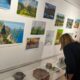 Posjetiteljica razgledava izložene likovne radove i predmete u galerijskom prostoru.