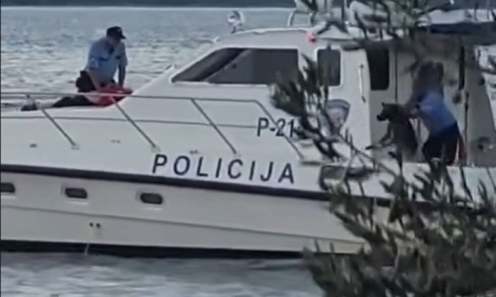 Policijski brod na moru s policijskim službenicima na palubi.