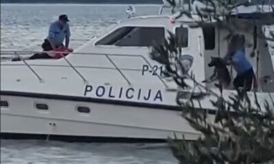 Policijski brod na moru s policijskim službenicima na palubi.