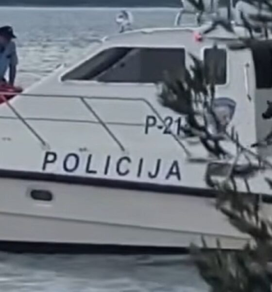 Policijski brod na moru s policijskim službenicima na palubi.