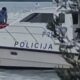 Policijski brod na moru s policijskim službenicima na palubi.