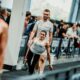 Sportašica s girjom u ruci tijekom natjecanja, uz trenera koji stoji iza nje.