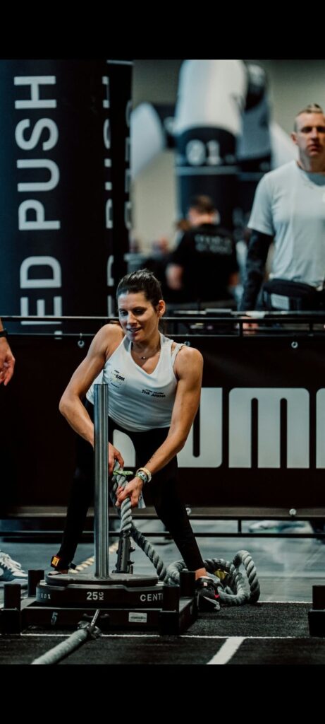 Sportašica tijekom natjecanja u funkcionalnom fitnessu povlači uže pričvršćeno za utege.