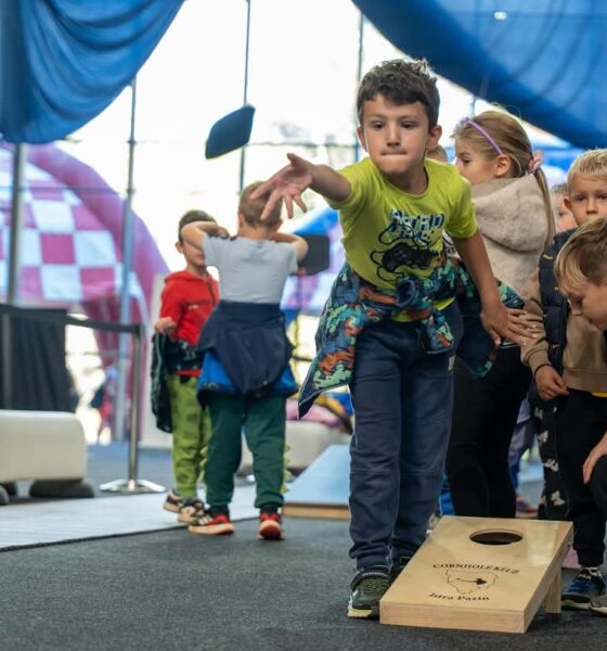 Fotografija prikazuje dječaka kako baca vrećicu i nastoji nešto pogoditi. Pokraj njega je više djece.