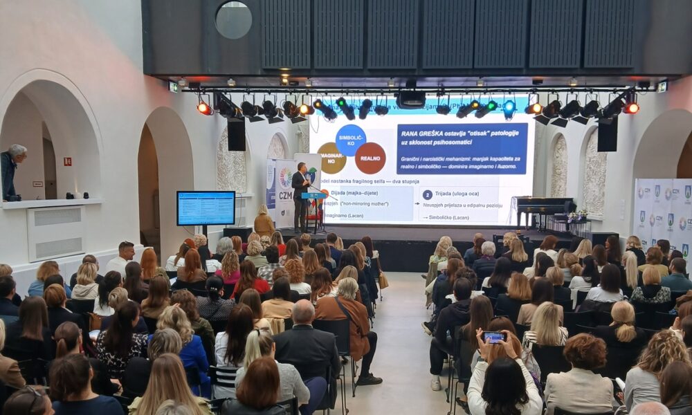 Publika prati izlaganje o mentalnom zdravlju na konferenciji u ispunjenoj dvorani.