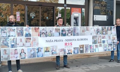 Na fotografiji su tri osobe koje ispred zgrade Ministarstva rada drže veliki transparent Regionalnog industrijskog sindikata (RIS). Na transparentu se nalazi velik broj fotografija osobnih asistenata i njihovih poruka, a u središnjem dijelu istaknuta je poruka „Naša prava – njihova sloboda“ uz logo RIS-a. Fotografije i poruke na transparentu prikazuju osobne asistente koji žele ukazati na svoj položaj i probleme s kojima se susreću u radu. U pozadini se vidi ulaz u zgradu Ministarstva, kao i bankomat te oznake institucija smještenih u zgradi. Fotografija tako vizualno prikazuje sindikalno okupljanje i poruku osobnih asistenata da njihov rad i prava moraju biti prepoznati i poštovani.