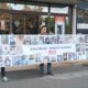 Na fotografiji su tri osobe koje ispred zgrade Ministarstva rada drže veliki transparent Regionalnog industrijskog sindikata (RIS). Na transparentu se nalazi velik broj fotografija osobnih asistenata i njihovih poruka, a u središnjem dijelu istaknuta je poruka „Naša prava – njihova sloboda“ uz logo RIS-a. Fotografije i poruke na transparentu prikazuju osobne asistente koji žele ukazati na svoj položaj i probleme s kojima se susreću u radu. U pozadini se vidi ulaz u zgradu Ministarstva, kao i bankomat te oznake institucija smještenih u zgradi. Fotografija tako vizualno prikazuje sindikalno okupljanje i poruku osobnih asistenata da njihov rad i prava moraju biti prepoznati i poštovani.